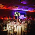 Decorated banquet hall with served round table with hydrangea centerpiece and chiavari chairs