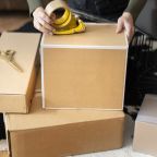 Small business owner packing product parcel boxes for delivery