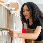 Manual worker using sander while working on a wood in carpentry workshop.