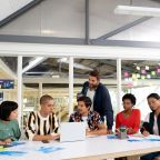 Front view of diverse business people discussing over laptop in the conference room at office